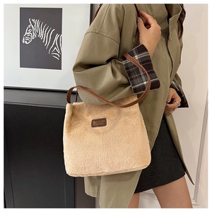 Détail du sac fourre-tout en peluche beige avec bandoulière en cuir et logo patch