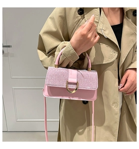 Detail of a pink luxury handbag with shimmering sequin flap and gold metallic lock closure