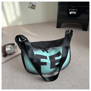Détail du sac bandoulière en nylon dégradé vert avec imprimé FE et étiquette logo