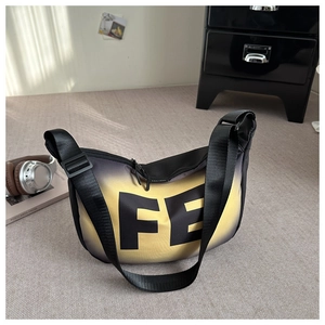 Détail du sac à bandoulière dégradé noir et jaune avec imprimé FE en décor moderne