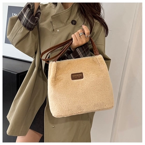 Détail du cabas en peluche avec étiquette en cuir marron et fausse fourrure beige douce