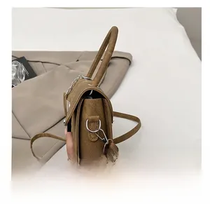 Details der silbernen Beschläge und des abnehmbaren Riemenhakens der braunen Tasche