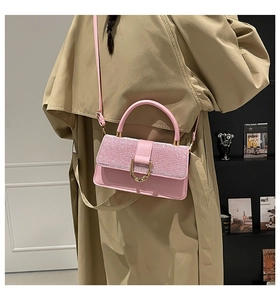 Detail of pink sequin patchwork handbag with gold horseshoe buckle and crossbody strap