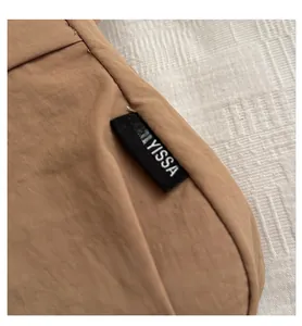 Close-up of the khaki woven fabric texture and black FANYISSA brand label on the bag