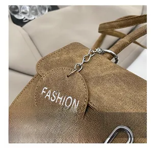 Nahaufnahme der braunen Twill-Textur und Metallschnalle mit FASHION-Logo-Anhänger