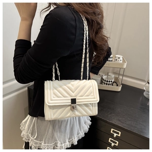 Detailed back view of a white quilted crossbody bag with a metal chain strap and silver lock
