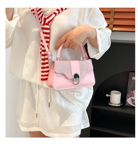 Detail of pink sequined flap handbag with silver metal lock and textured PU leather