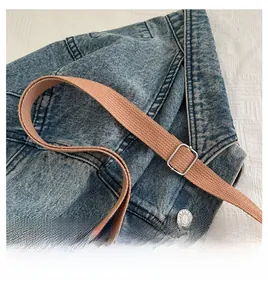 Detail of khaki shoulder bag strap featuring woven texture and silver metal buckle