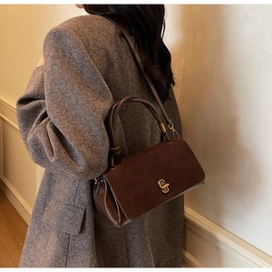 Detail of brown suede and smooth leather shoulder bag with gold twist lock buckle