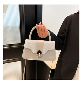 Detail showing the elegant glitter texture and silver metal ring buckle on the white handbag