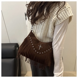 Dettaglio borsa a tracolla marrone con frange, borchie e croce in stile boho
