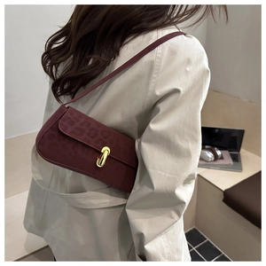 Dettaglio borsa a spalla bordeaux maculata con elegante chiusura in metallo dorato