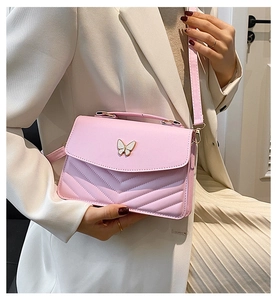 Détail du sac bandoulière rose en cuir PU avec boucle papillon et finitions surpiquées
