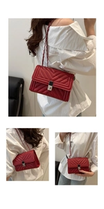 Detailed view of red quilted leather bag with V-shaped stitching and chain strap