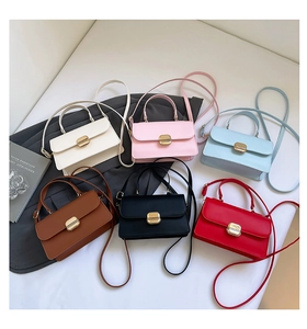 Close-up of minimalist square handbags in six colors with gold clasps and top handles