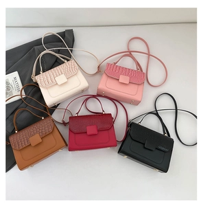 Flat lay of small flap crossbody bags in five colors with faux crocodile texture detail