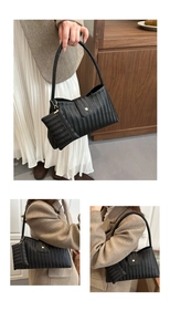 Detail of black woven underarm bag featuring a matching coin purse and magnetic clasp