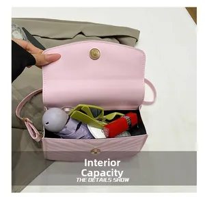 Vue de dessus montrant la capacité interne du sac bandoulière rose matelassé avec objets