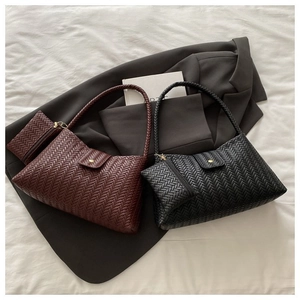 Detail of woven leather shoulder bags in dark brown and black with matching mini pouches