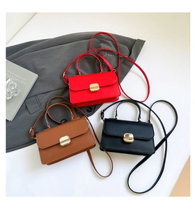 Detailed shot of leather mini flap bags in red, brown, and black with gold metal buckles