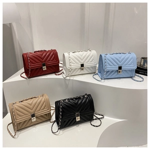 Close-up of quilted chain bags in five colors on a white minimalist display stand