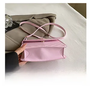 Vue détaillée de la base résistante à l'usure et du sac bandoulière rose en cuir surpiqué