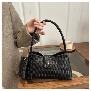 Close-up of black woven leather shoulder bag with matching mini pouch and gold hardware