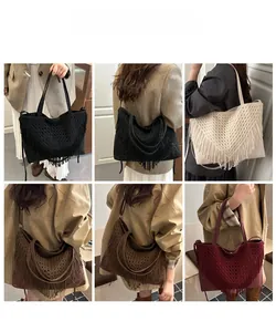 Dettaglio di borse tote boho in maglia con lunghe frange in nero, bianco, marrone e bordeaux