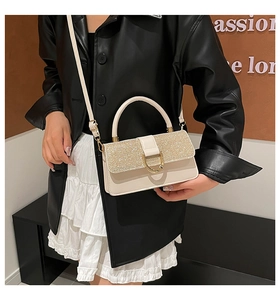 Detail of cream crossbody bag with champagne sequin flap and gold D-ring hardware