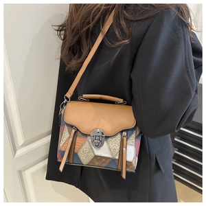 Detail of color-block crossbody bag with geometric textures and gold metal clasp closure