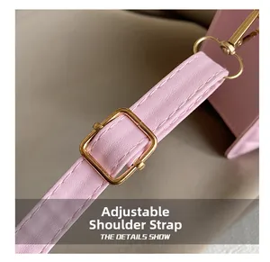 Gros plan de la bandoulière réglable en cuir rose avec boucle en métal doré de qualité