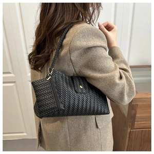 Detail of black woven hobo bag with matching mini pouch and elegant braided shoulder strap