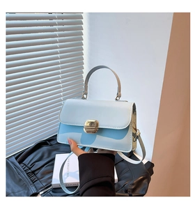 Detail of baby blue crossbody bag with gold buckle clasp and top handle for women
