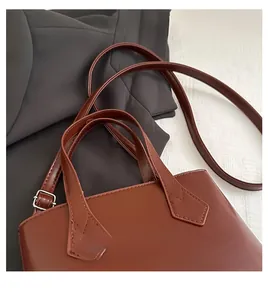 Detail view of brown PU leather bucket bag featuring comfortable top handles and stitching
