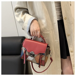 Detail of colorful geometric patchwork leather bag with metallic swivel lock and top handle