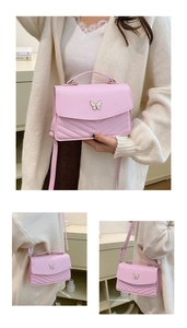Détail du sac bandoulière matelassé rose avec ornement papillon blanc et sangle réglable