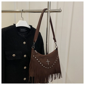 Borsa a tracolla marrone con frange, borchie vintage e croce in metallo su superficie scamosciata