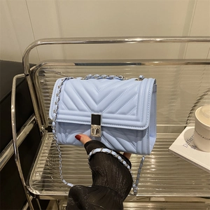 Elegant light blue quilted leather crossbody bag with silver chain and twist-lock clasp