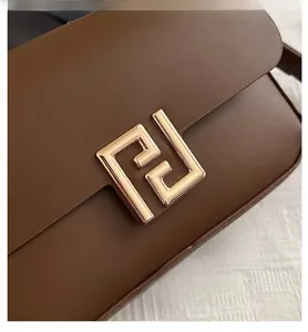 Dettaglio della borsa in pelle marrone scuro con fibbia in metallo dorato vintage