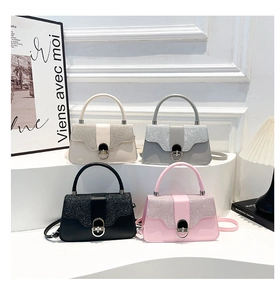 Detail of four stylish hard-shell mini bags in white, gray, black, and pink with glitter