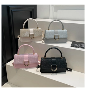 Detail view of four glittery small handbags in white, blue, pink, and black with gold buckles