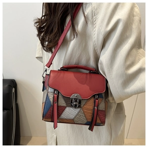 Close-up of a color-block patchwork handbag with metal buckle and litchi texture