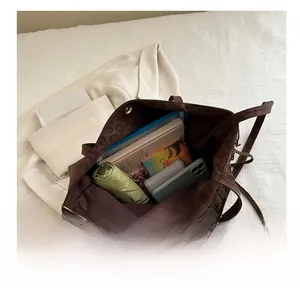 Interno della borsa tote marrone scuro con chiusura magnetica e articoli di uso comune