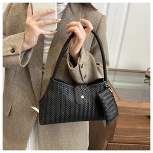 Detail of black woven shoulder bag with golden buckle and matching coin purse accessory