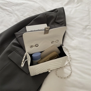 White quilted crossbody bag with metal chain strap and interior storage view
