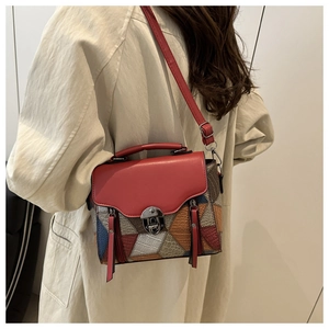 Detailed side view of stylish color-block crossbody bag with red flap and metal lock clasp