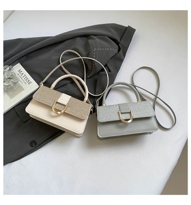 Close-up of glitter-stitched crossbody bags with gold locks on a stylish minimalist background