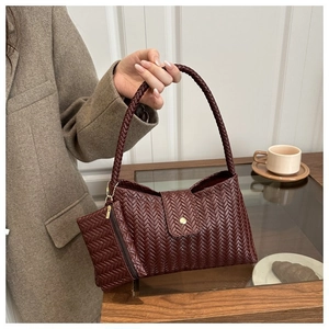 Detail of burgundy woven hobo bag with gold hardware and matching zipper pouch