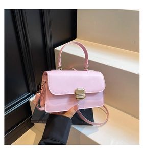 Detailed view of pink PU leather handbag with a golden rotating square metal clasp lock