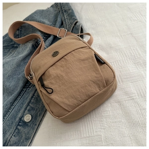 Close-up of khaki crossbody bag with nylon texture and adjustable shoulder strap